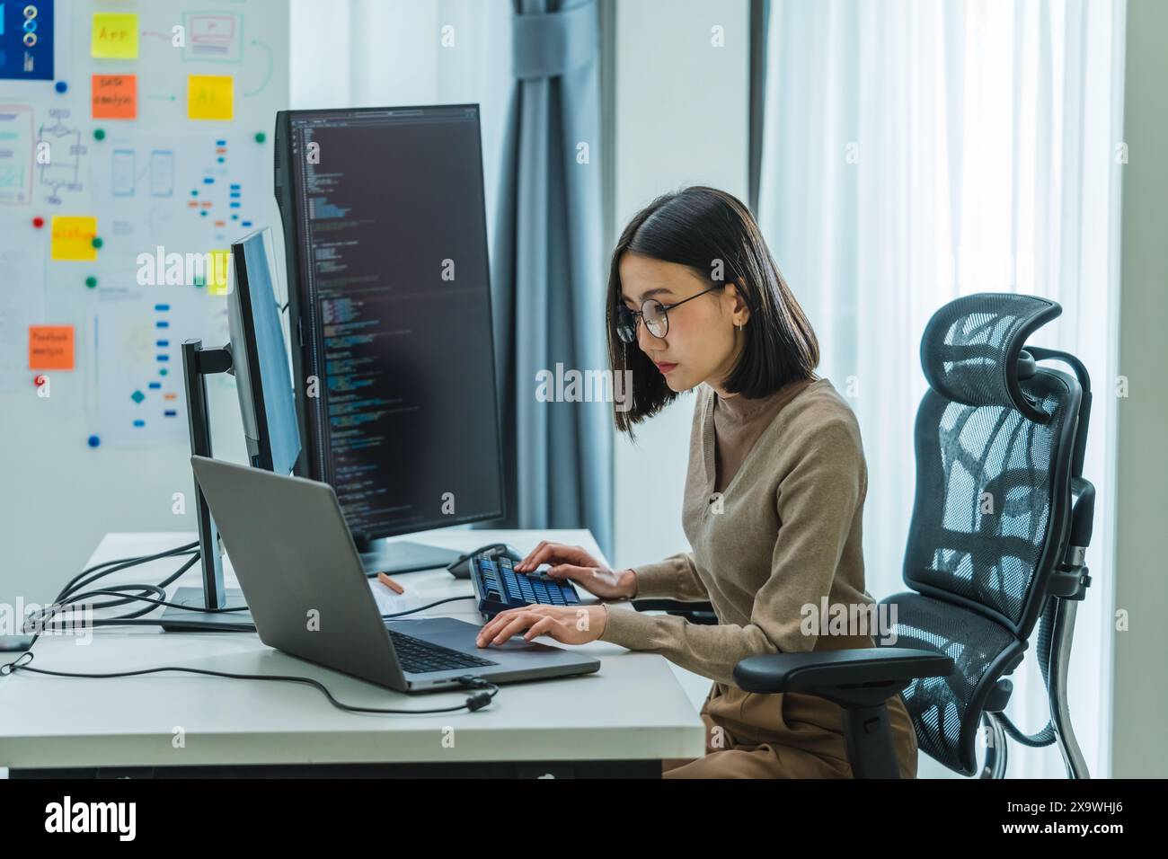 Asian prompt engineer develop coding app with software data sitting in ...