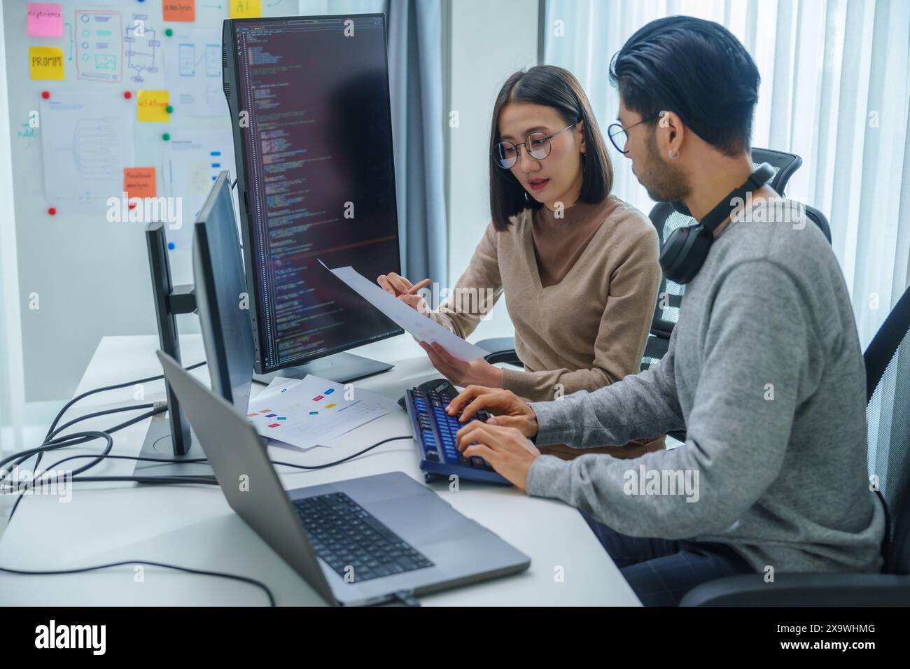 asian and Indian Developer team discussion feedback analysis coding data with software computer at office Stock Photo