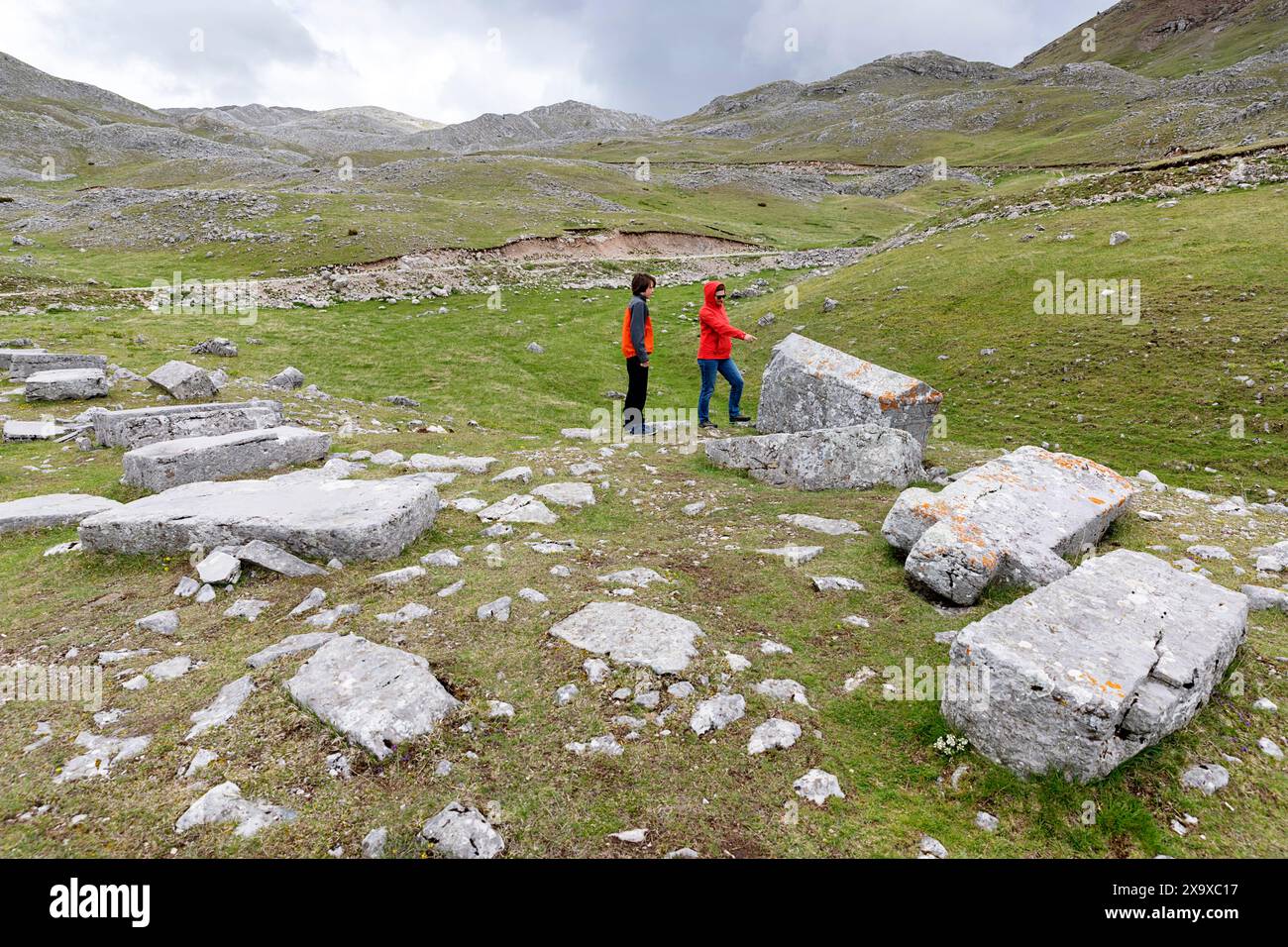 Mother and son, tourists on a family trip, exploring medieval tombstones on visocica plateaus, surrounded with mountain range, Bosnia and Hercegovina Stock Photo