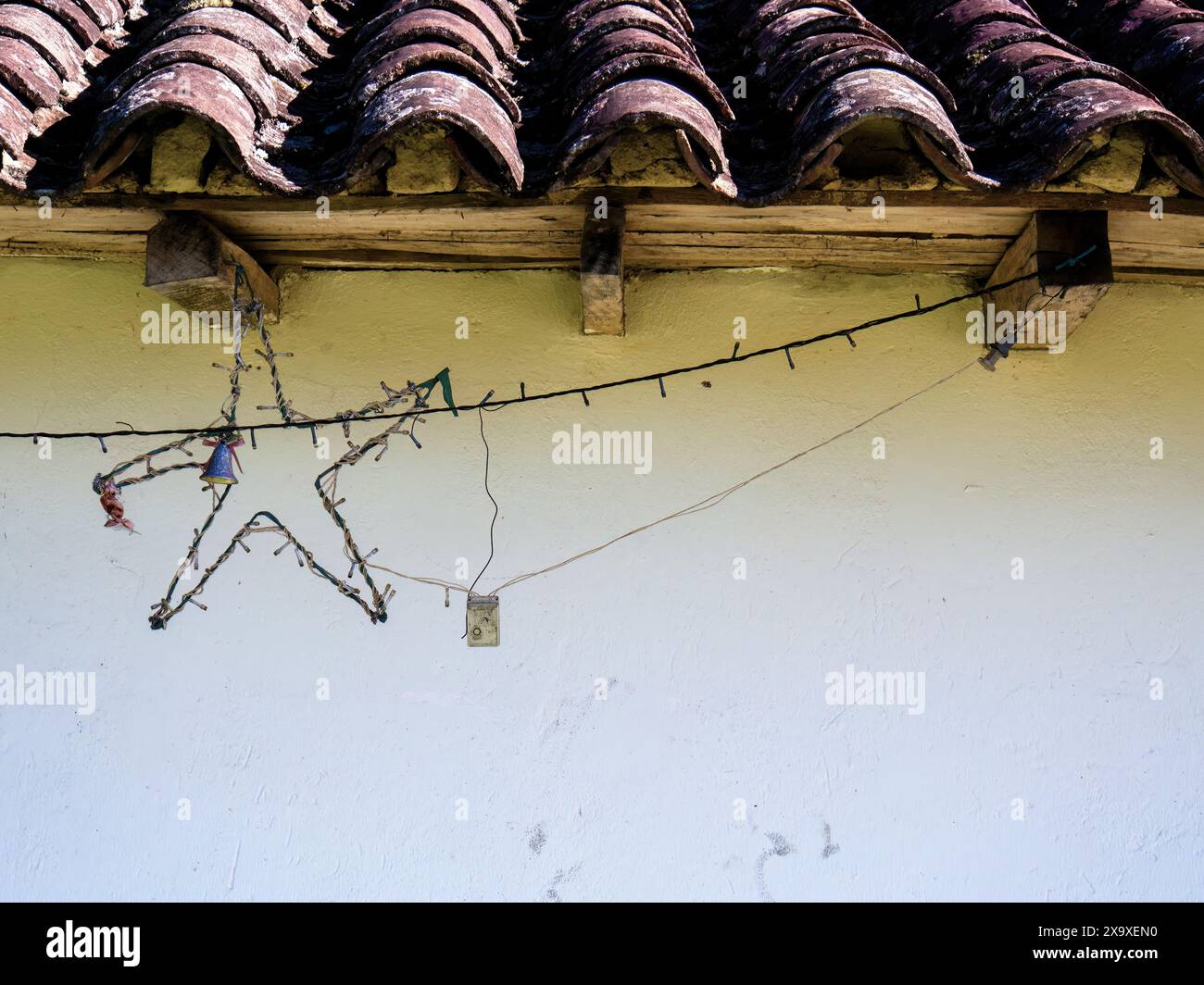 A neglected Christmas star and lights decoration hanging from a rustic ...
