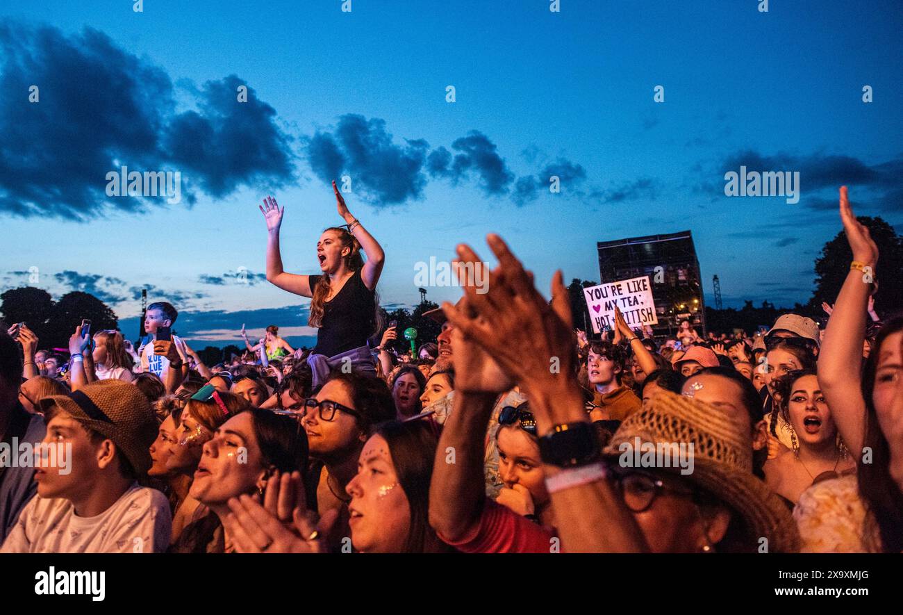 An excited large crowd cheers on George Ezra against a cloudy sky at the Latitude Festival at Henham Park in Suffolk. Stock Photo