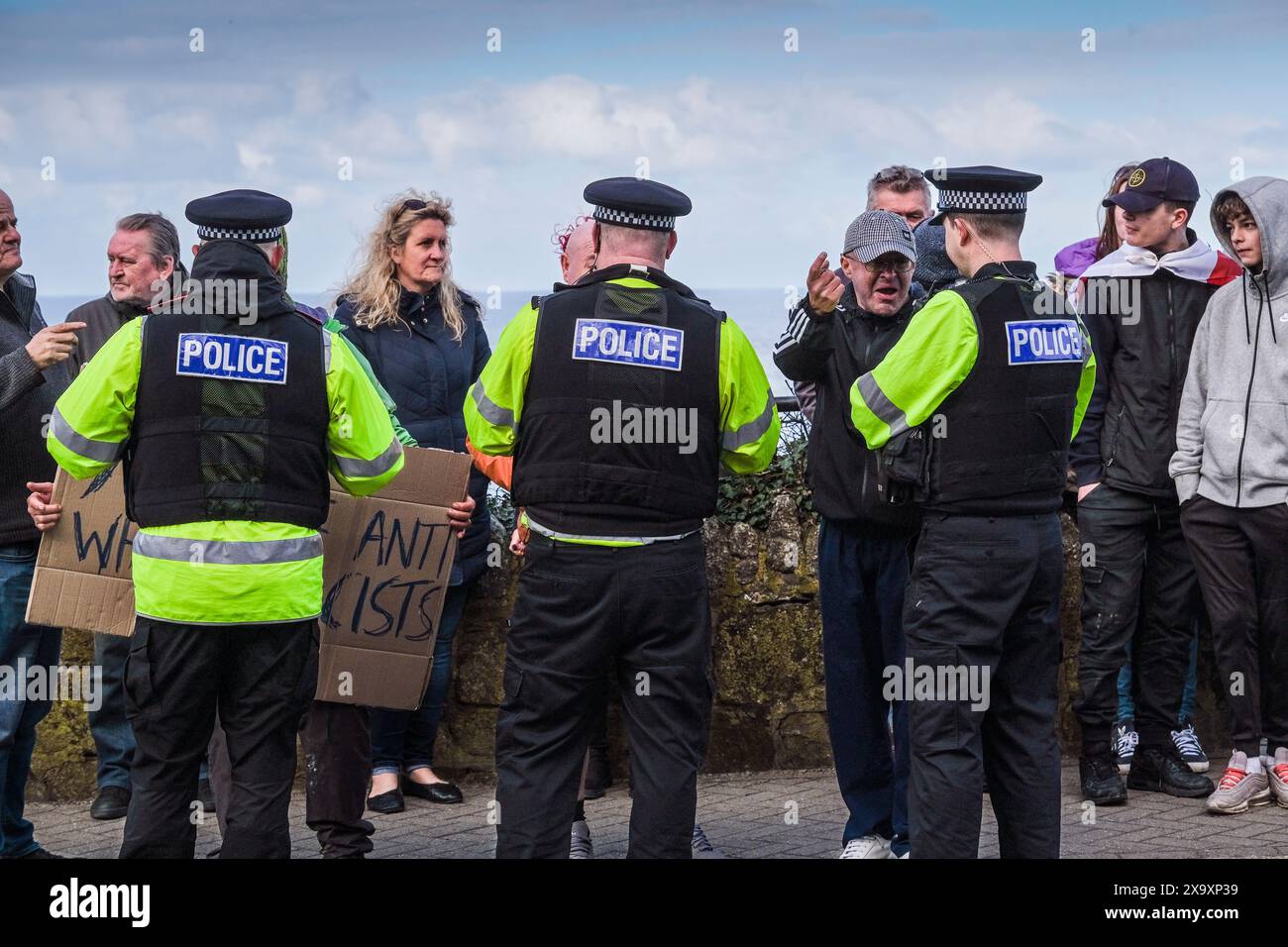 Devon and Cornwall police officers speaking to people protesting against asylum seekers being housed in the Beresford Hotel in Newquay in Cornwall in UK. Stock Photo