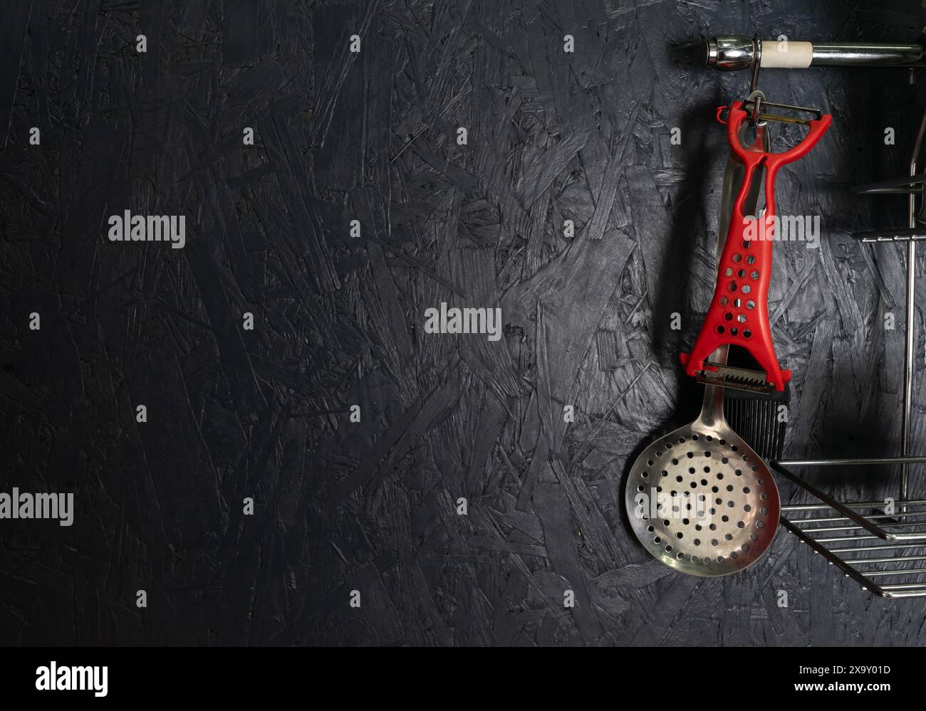 Kitchen utensils on a black wall. Copy space Stock Photo