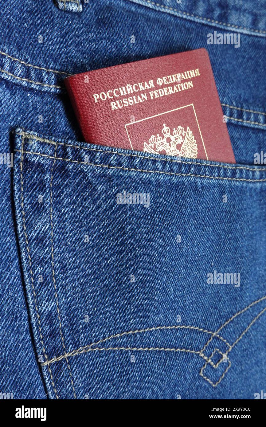 Red Russian Federation foreign passport in the blue jeans back pocket close-up photo Stock Photo