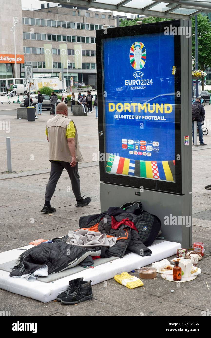 Schlafplatz eines Wohnungslosen vor einem Willkommensschild Display zur