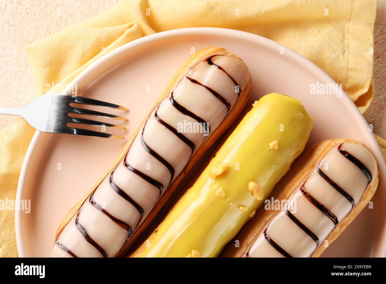 Different tasty glazed eclairs served on table, top view Stock Photo