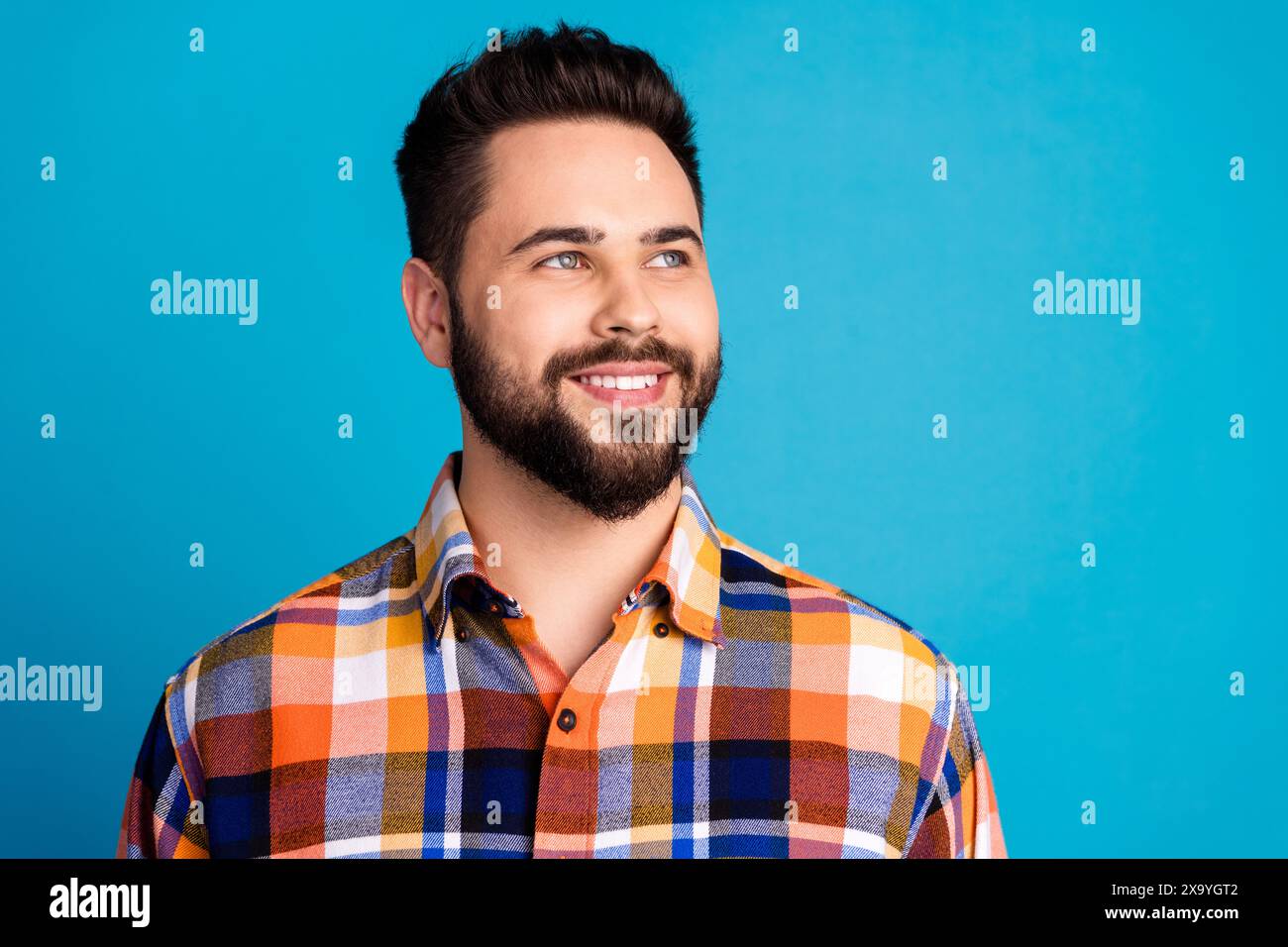 Photo of nice young man look empty space wear shirt isolated on blue ...