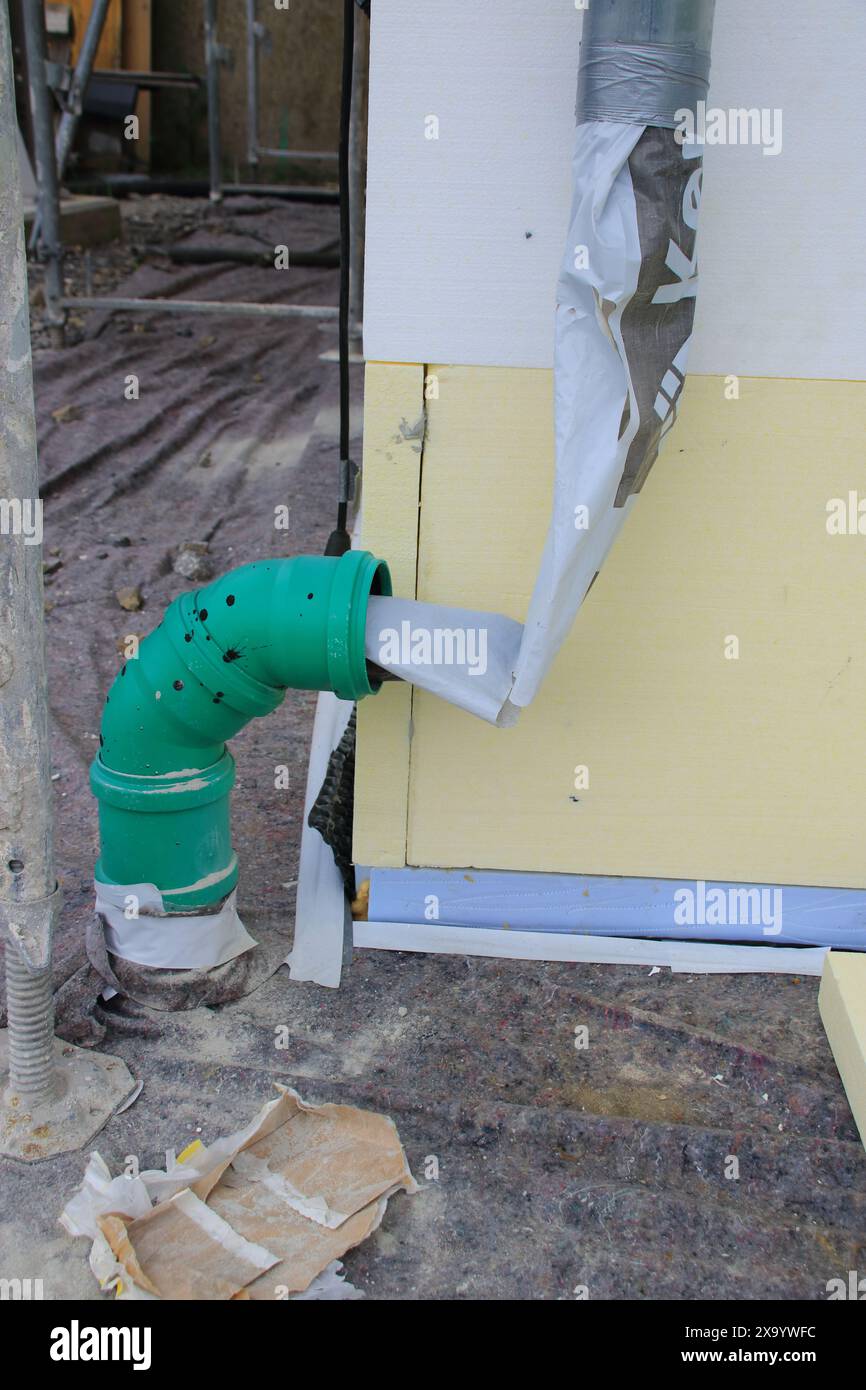 Water from a downspout is redirected using a hose Stock Photo