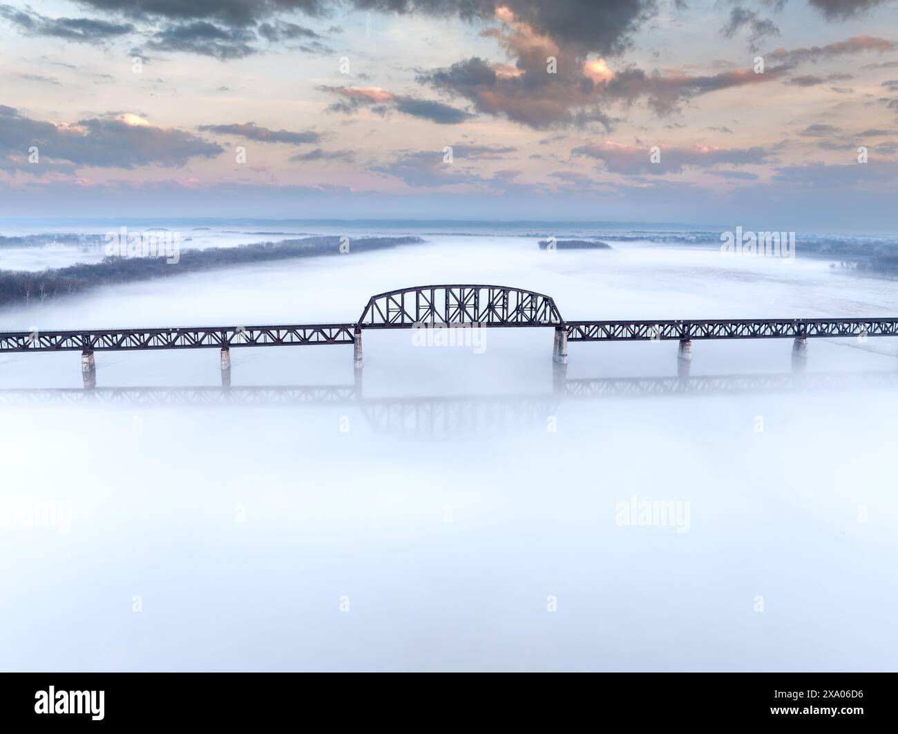 A bridge spanning over fog with a river below Stock Photo - Alamy