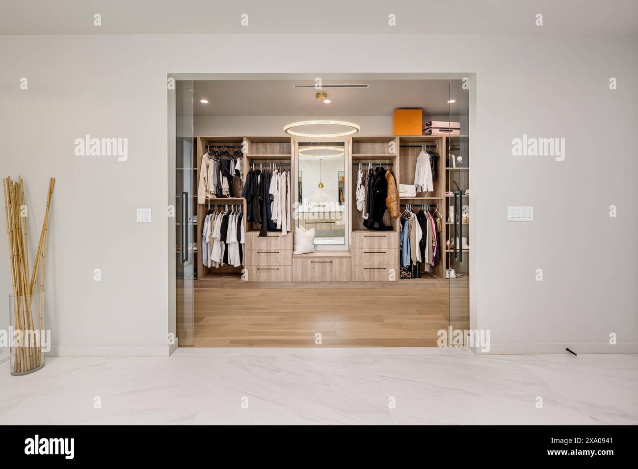 Spacious walk-in closet with numerous drawers and hanging clothes Stock Photo