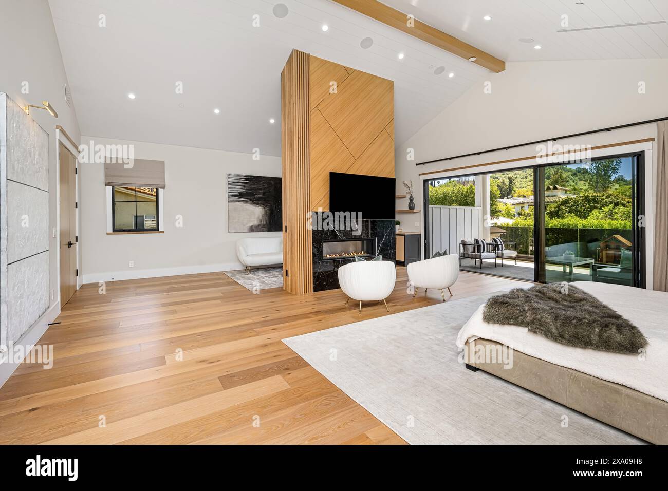 Spacious bedroom with glass doors opening to patio and backyard access ...