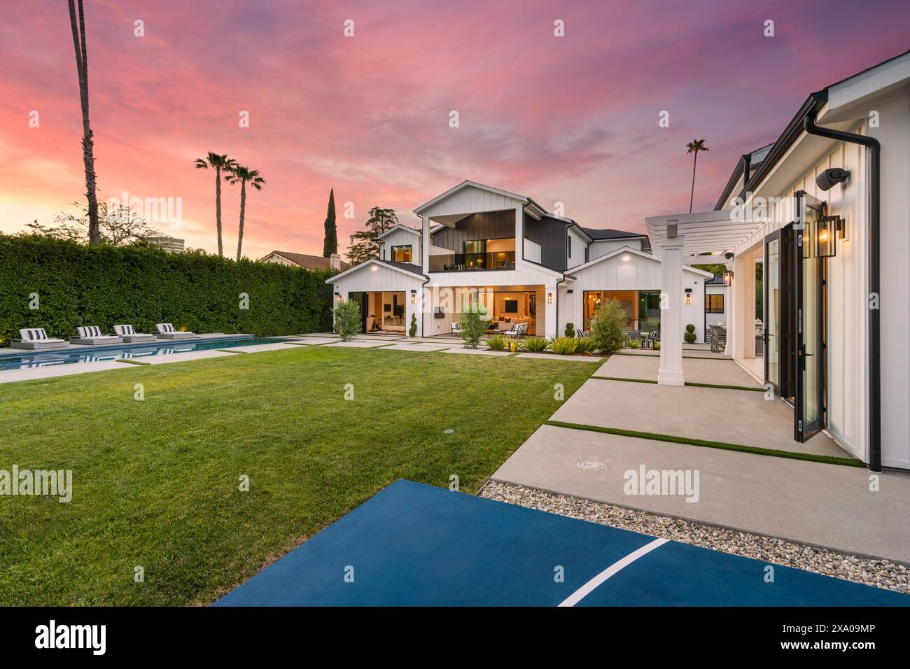 Basketball court with adjacent house and patio featuring a tennis table ...