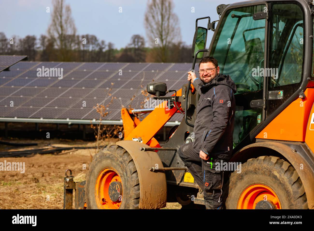 A construction worker installing solar panels in Germany Stock Photo