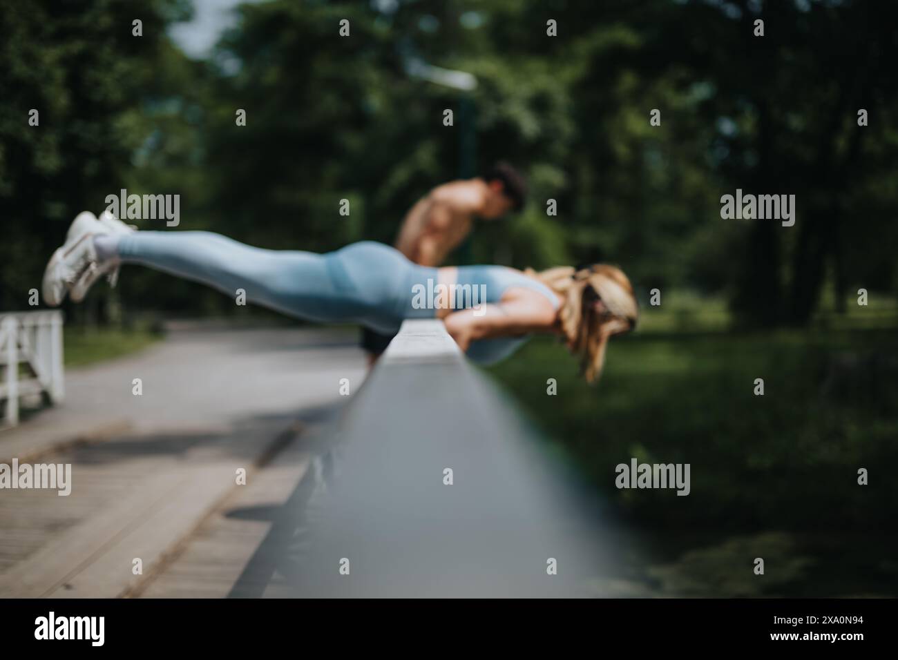 Man and woman performing plank exercises on park railing outdoors Stock ...