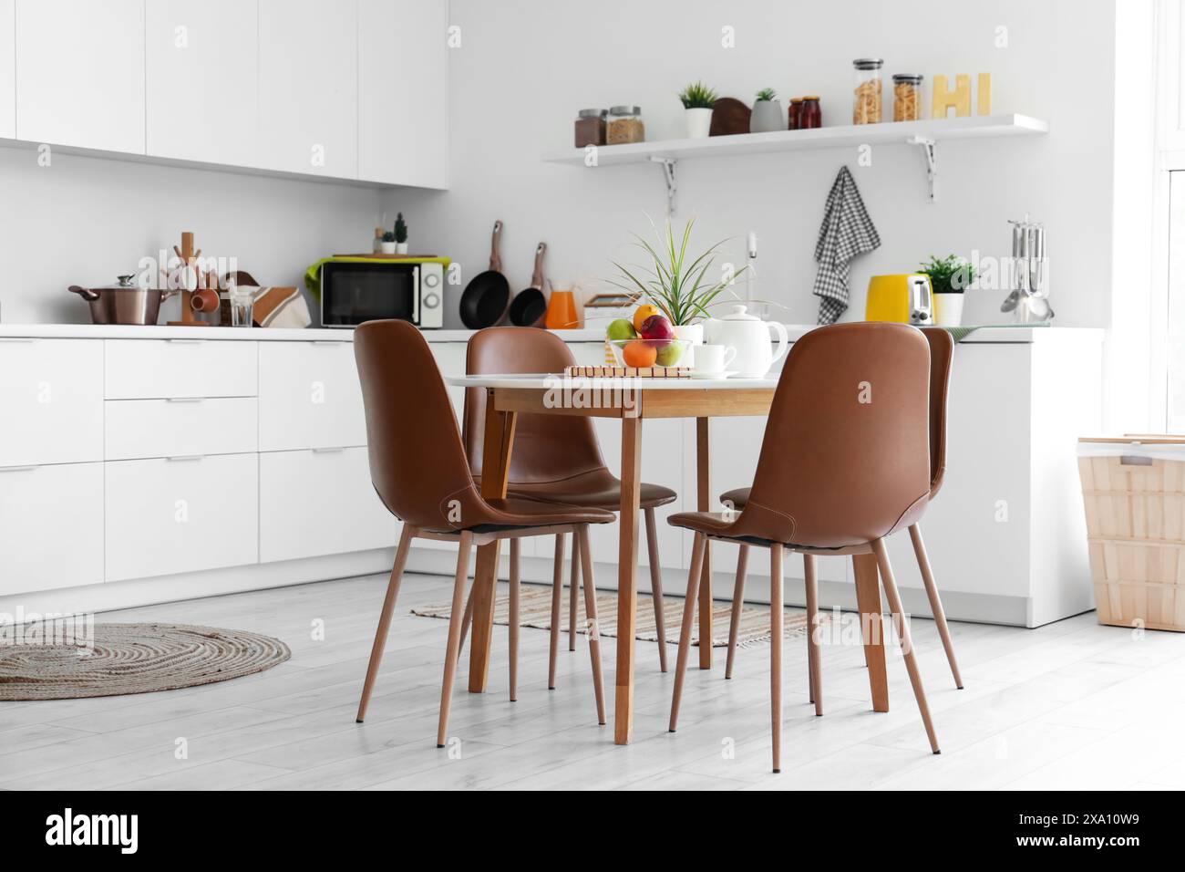 Interior of light kitchen with dining table and counters Stock Photo ...
