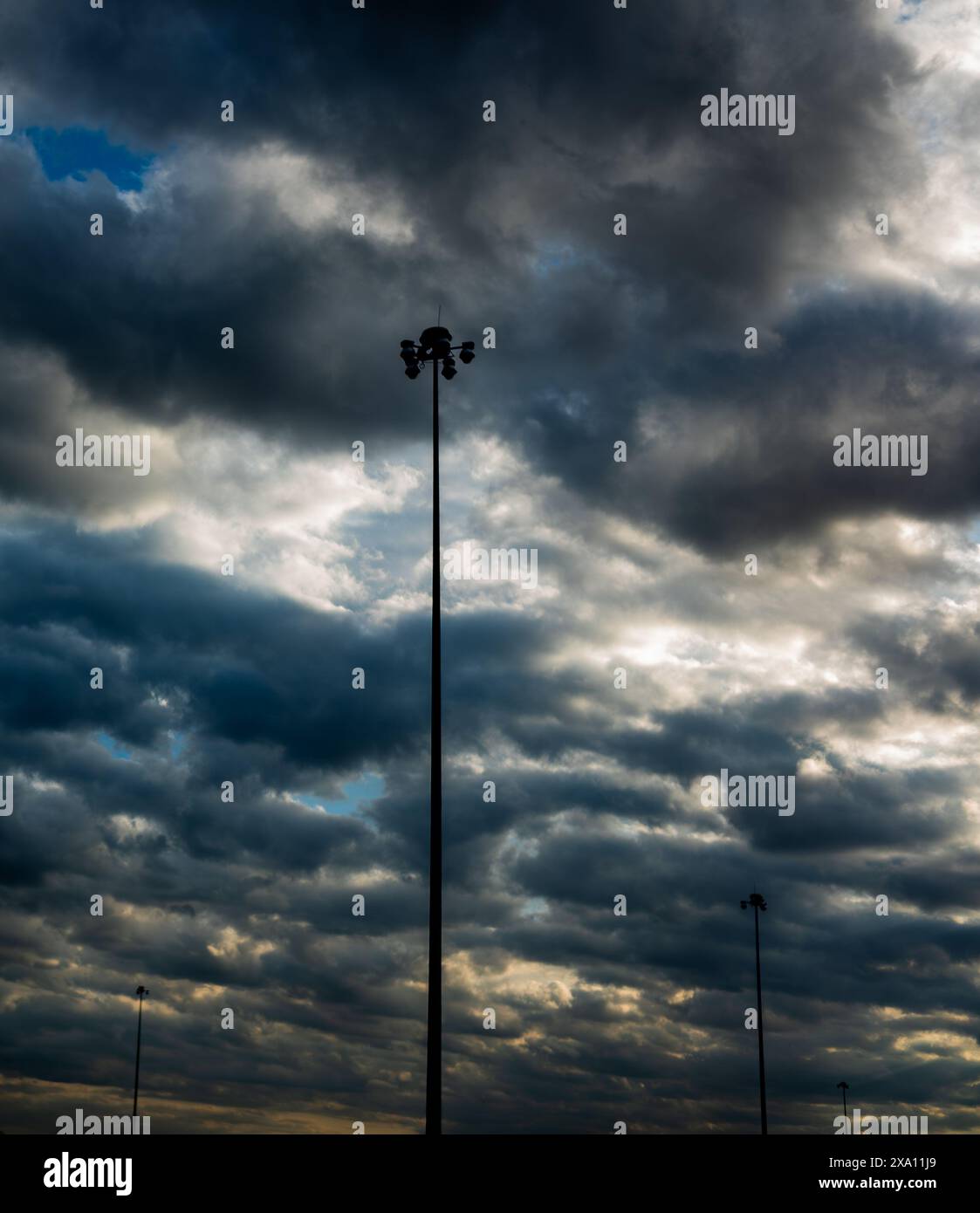 The dramatic dark clouds with lights shining through them Stock Photo