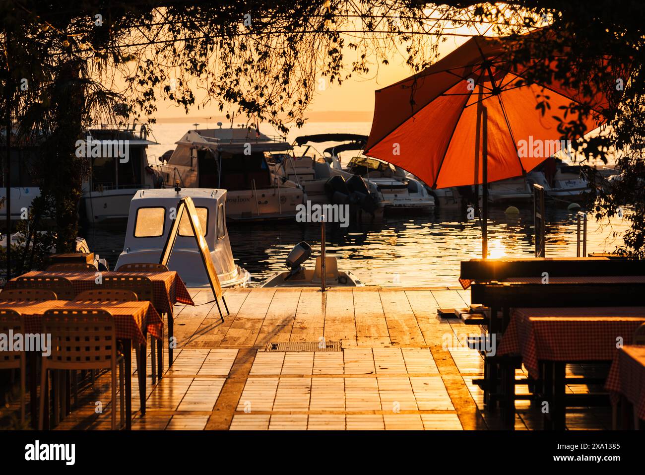 An umbrella-covered outdoor seating by the waterfront in Selce, Croatia. Stock Photo