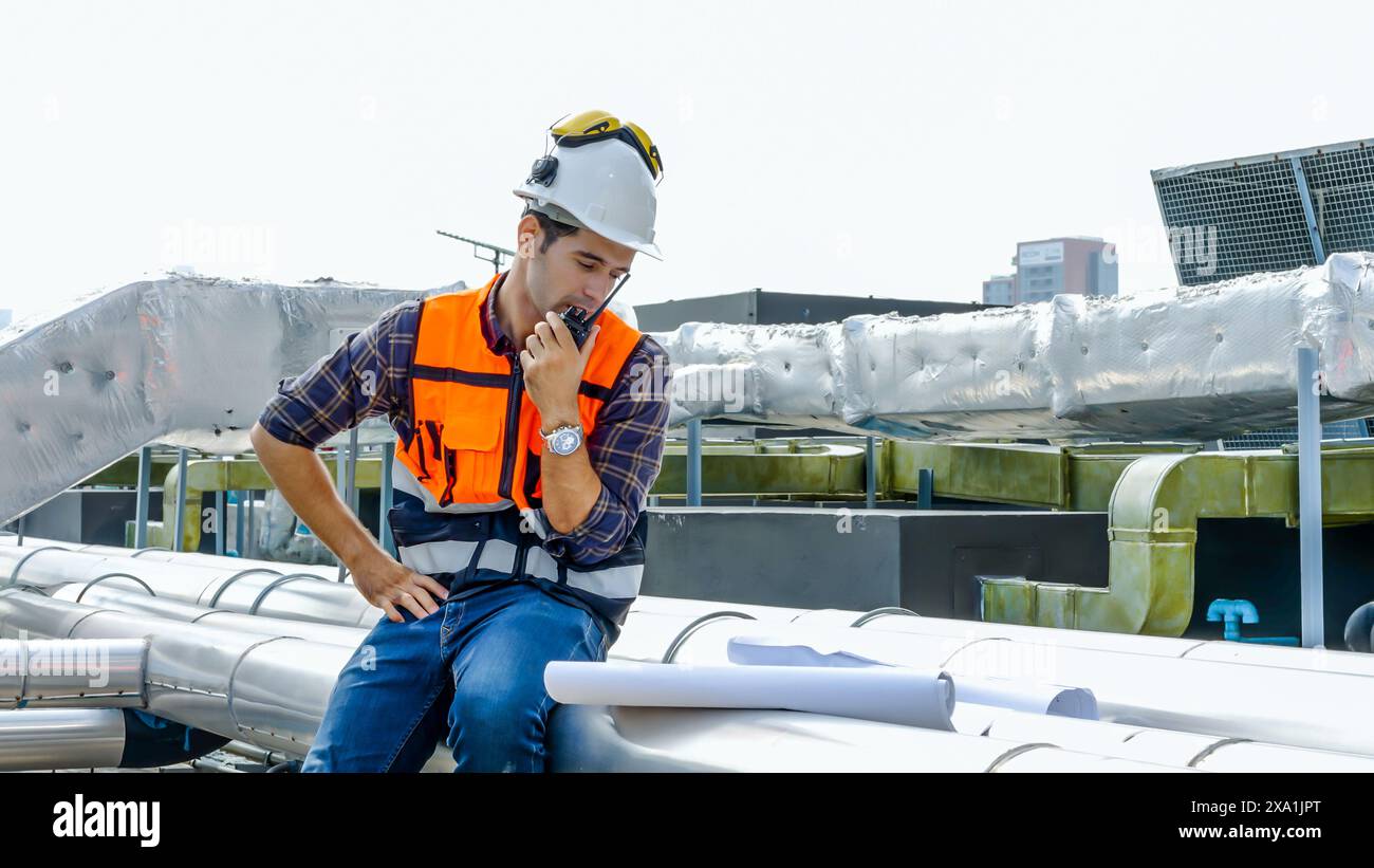 An engineer talking on a walkie-talkie at a construction site. Stock Photo