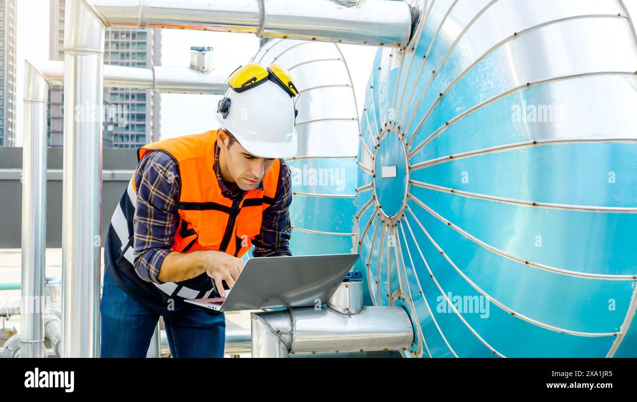 An engineer working on a laptop at a building site. Stock Photo