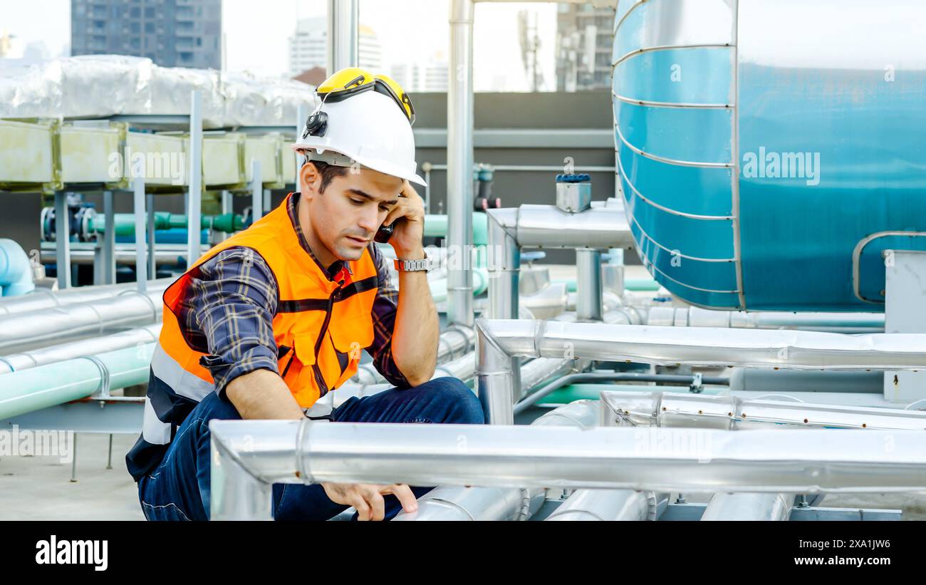 An engineer talking on a walkie-talkie at a construction site. Stock Photo