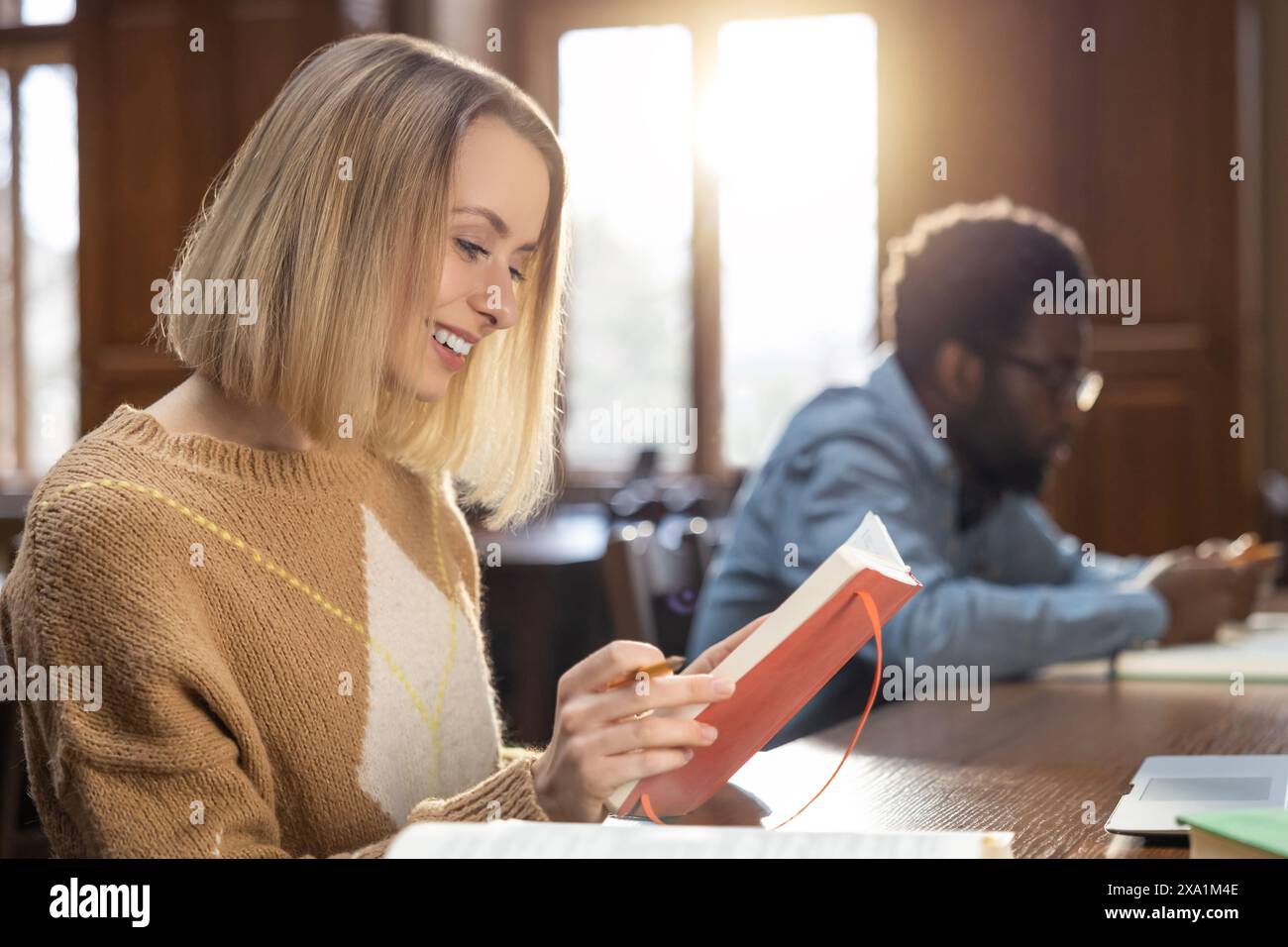 Studying together. Young man and woman studying in the library ad looking focused Stock Photo