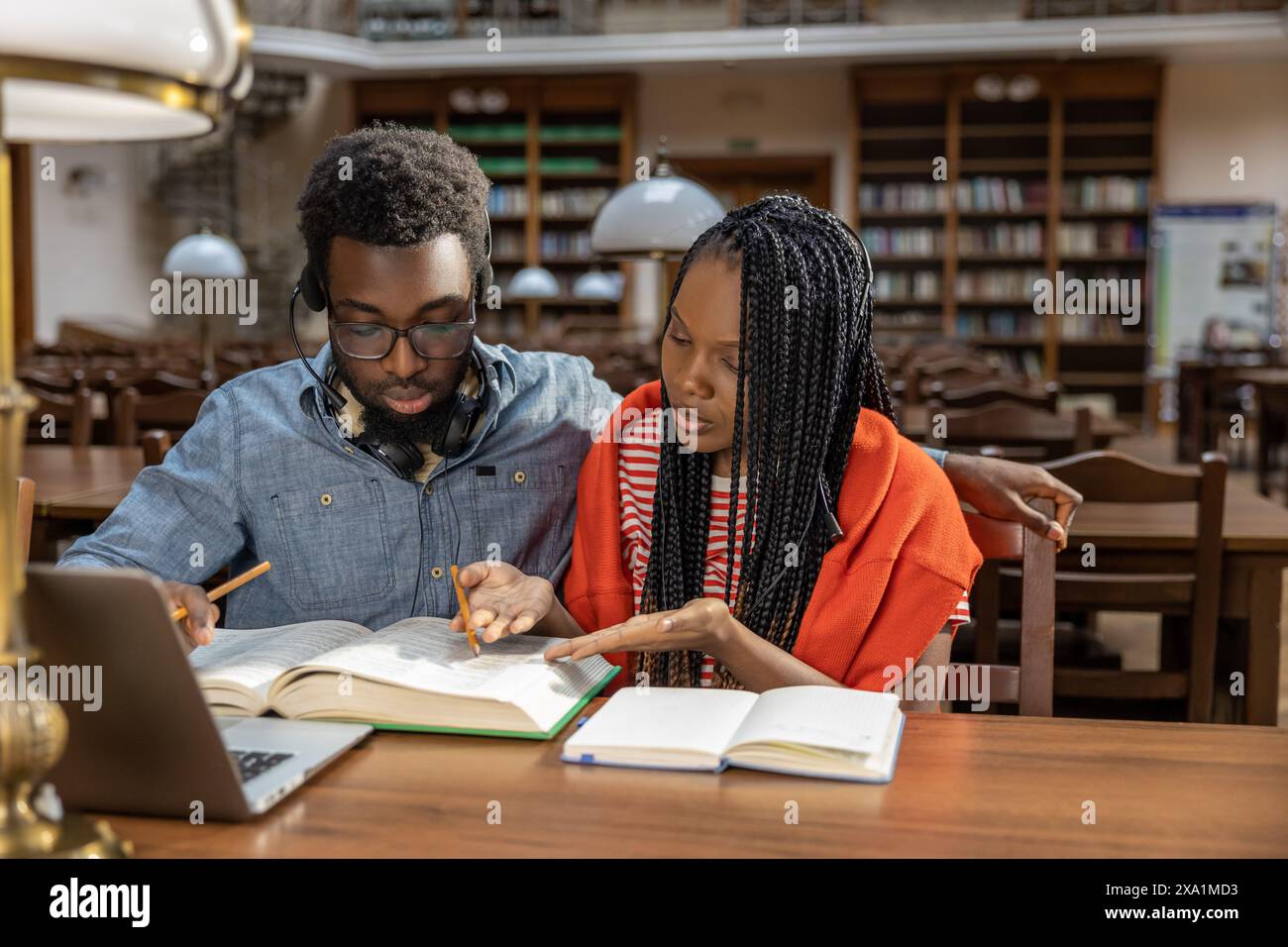 Studying together. Dark-skinned couple studying together in the library Stock Photo