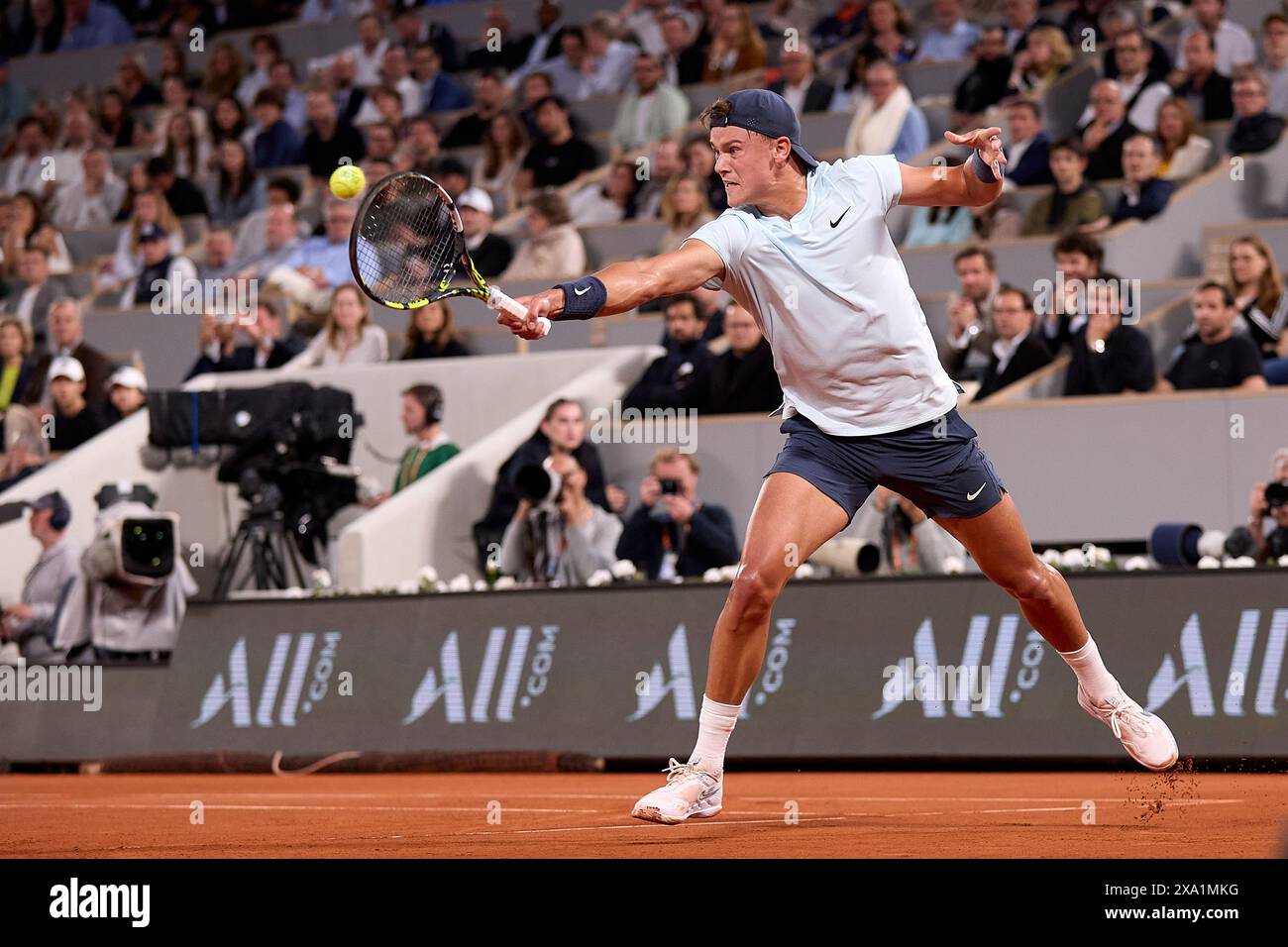 Holger Rune of Denmark returns a ball against Alexander Zverev of ...