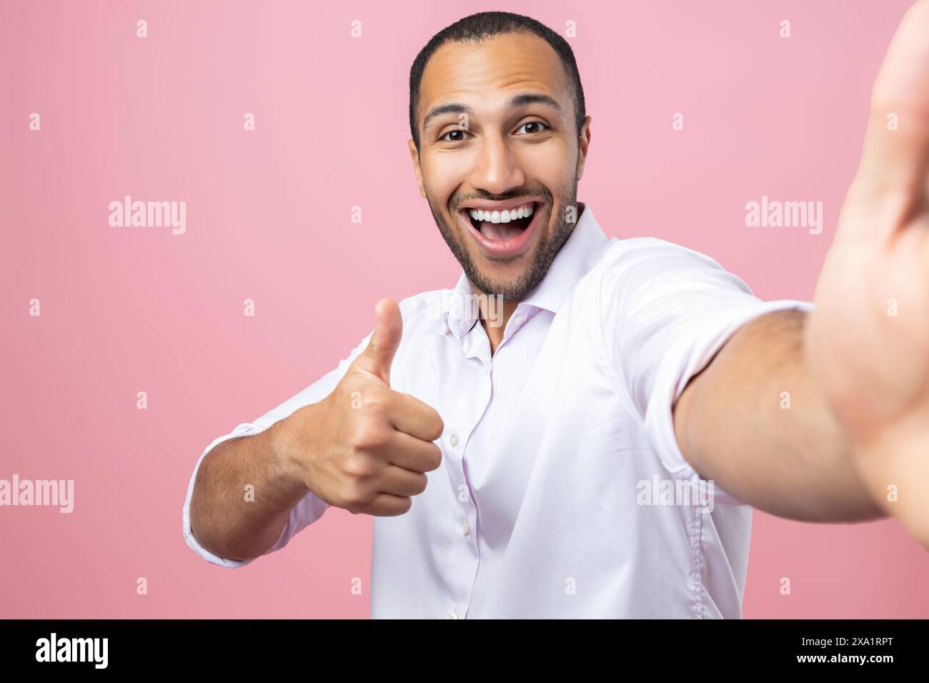 Amazed man in white shirt making pov photo showing like gesture isolated over pink background Stock Photo