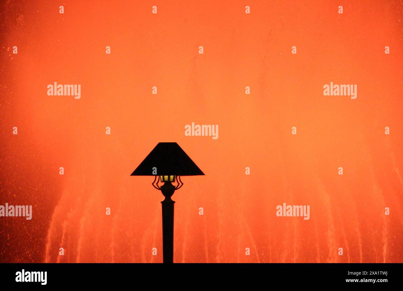 A lamp against a reddish glowing backdrop Stock Photo