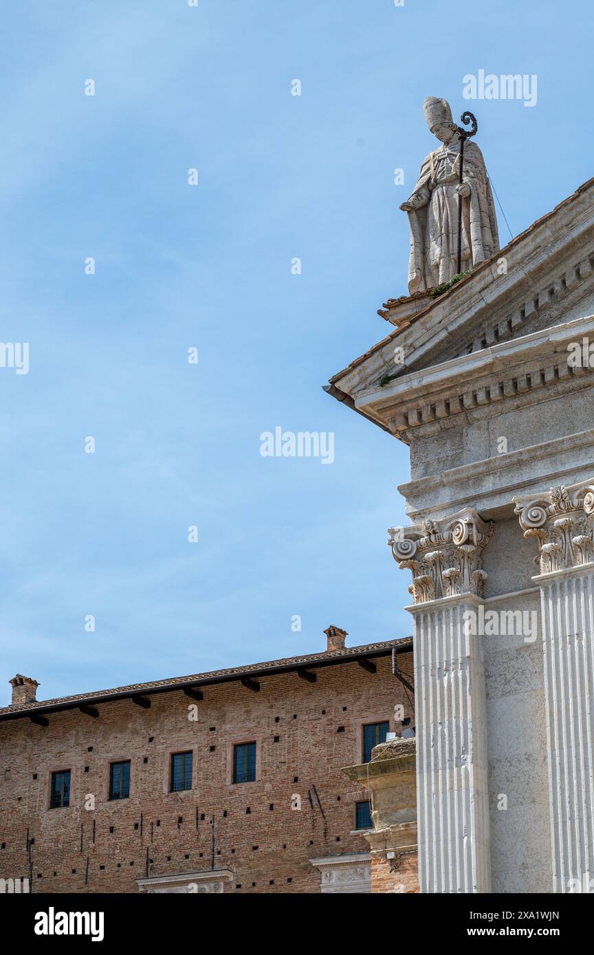 A building with a sculpture on the roof in the province of Pesaro and Urbino Stock Photo