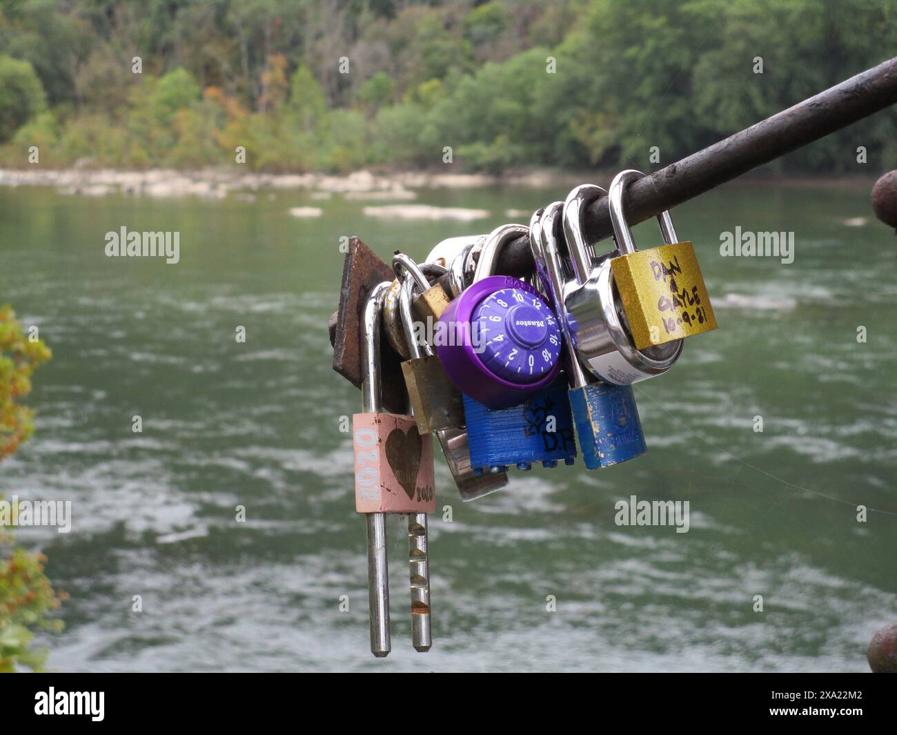 Numerous locks hanging on a dock by the water Stock Photo