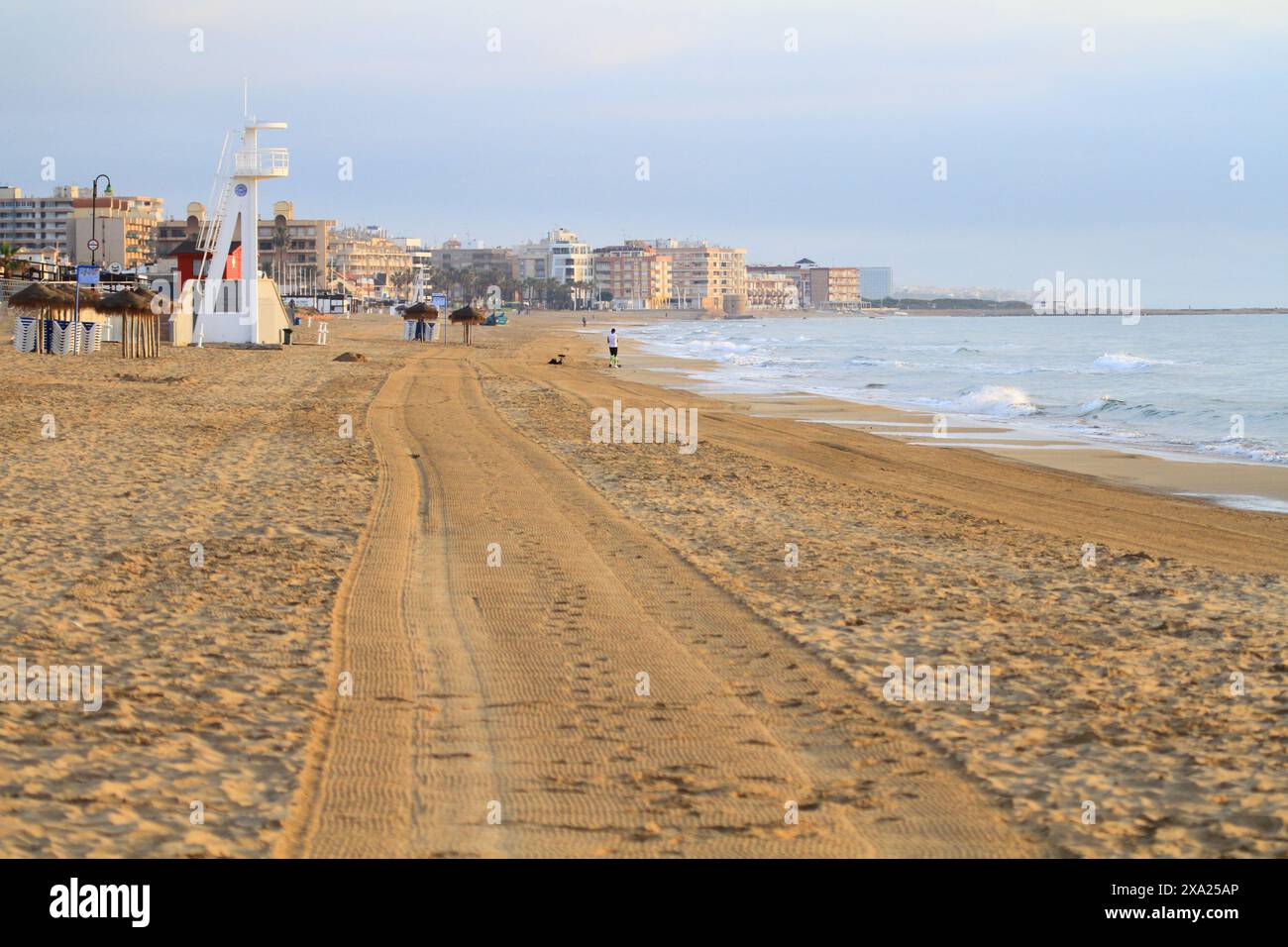 People strolling on sandy beach by the ocean Stock Photo