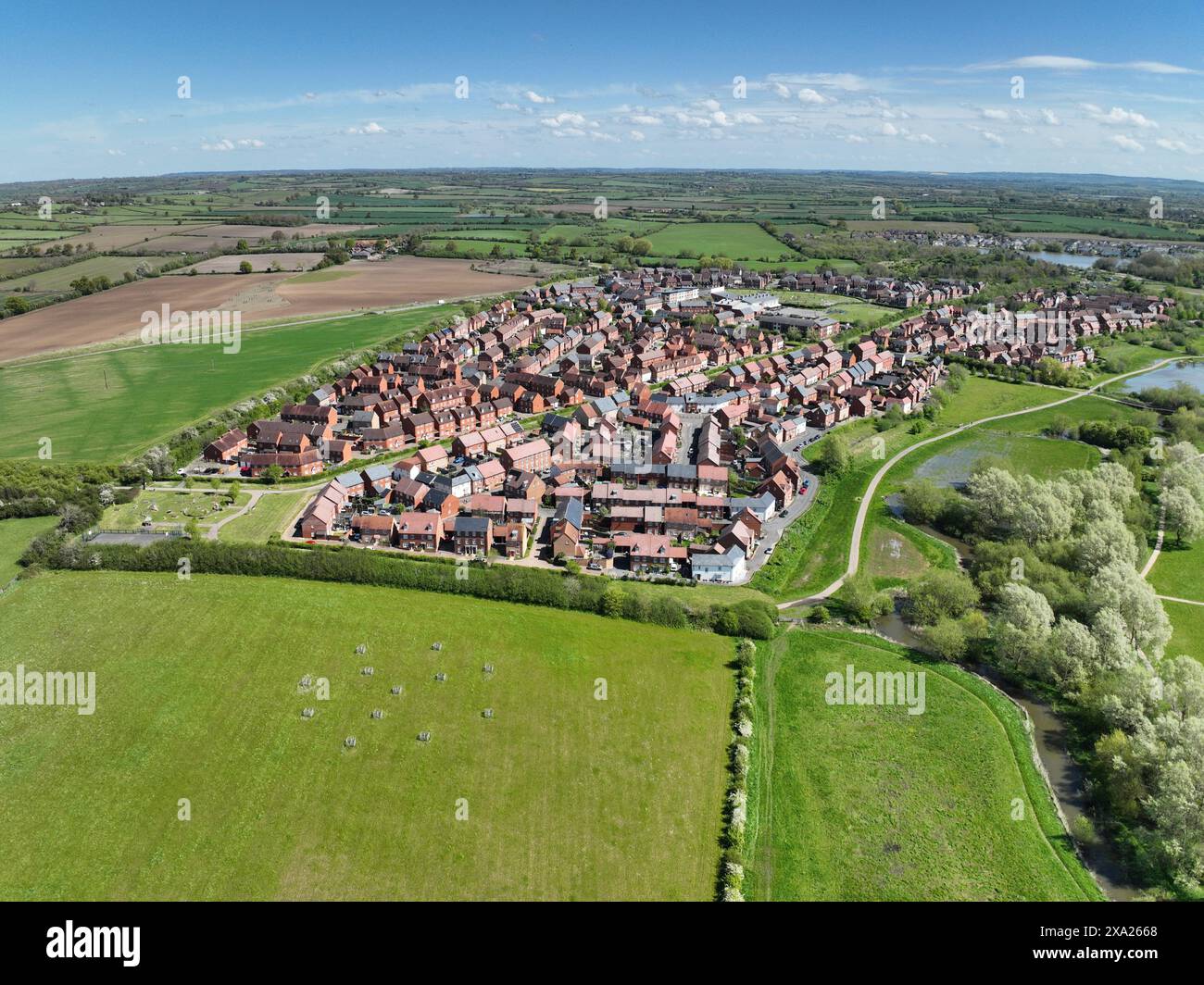Drone photography of an English housing estate in Aylesbury. Buckingham Park in May 2024. Aerial view of a housing estate surrounded by green fields Stock Photo