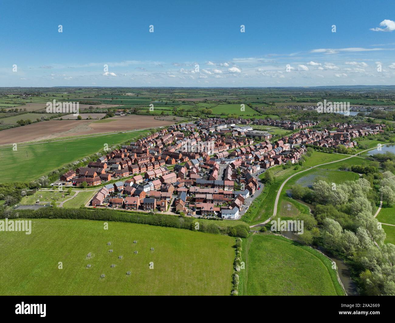 Drone photography of an English housing estate in Aylesbury. Buckingham Park in May 2024. Aerial view of a housing estate surrounded by green fields Stock Photo