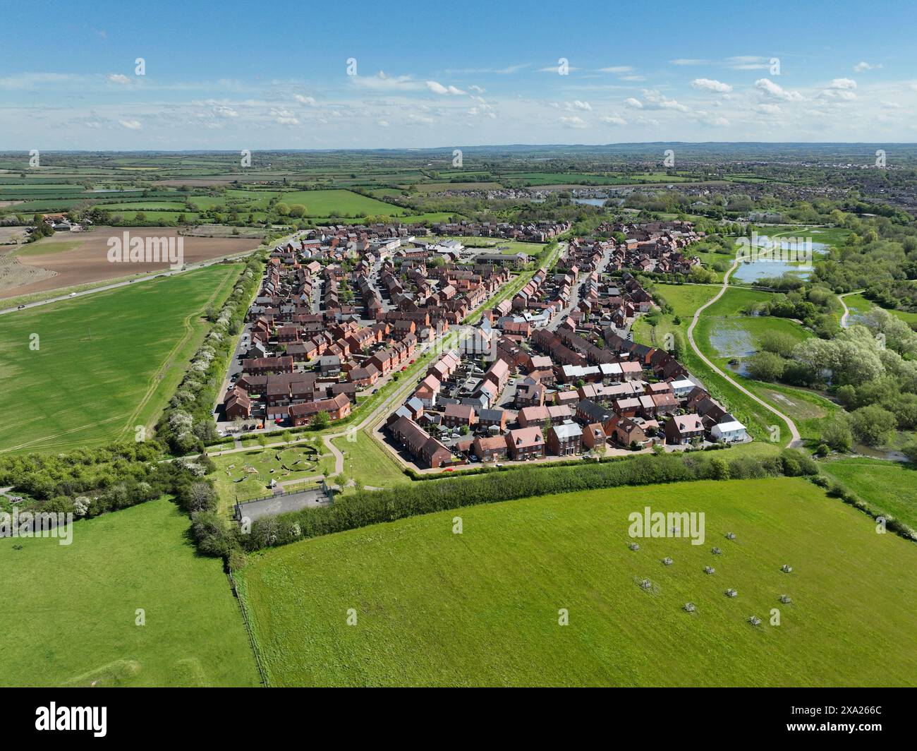 Drone photography of an English housing estate in Aylesbury. Buckingham Park in May 2024. Aerial view of a housing estate surrounded by green fields Stock Photo