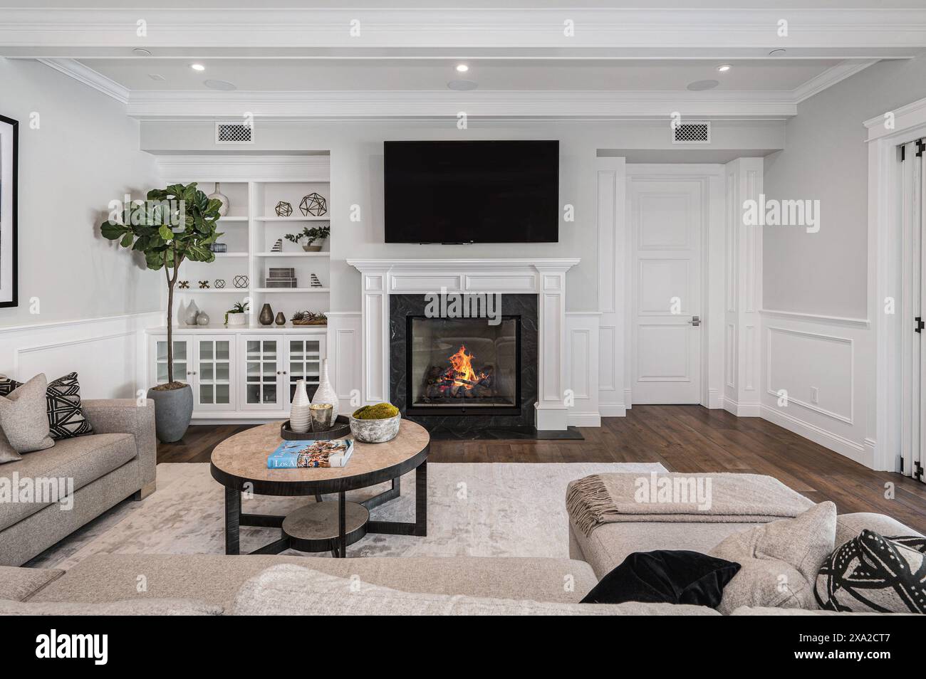 A cozy living room with a fireplace in a new construction home in Encino, California Stock Photo
