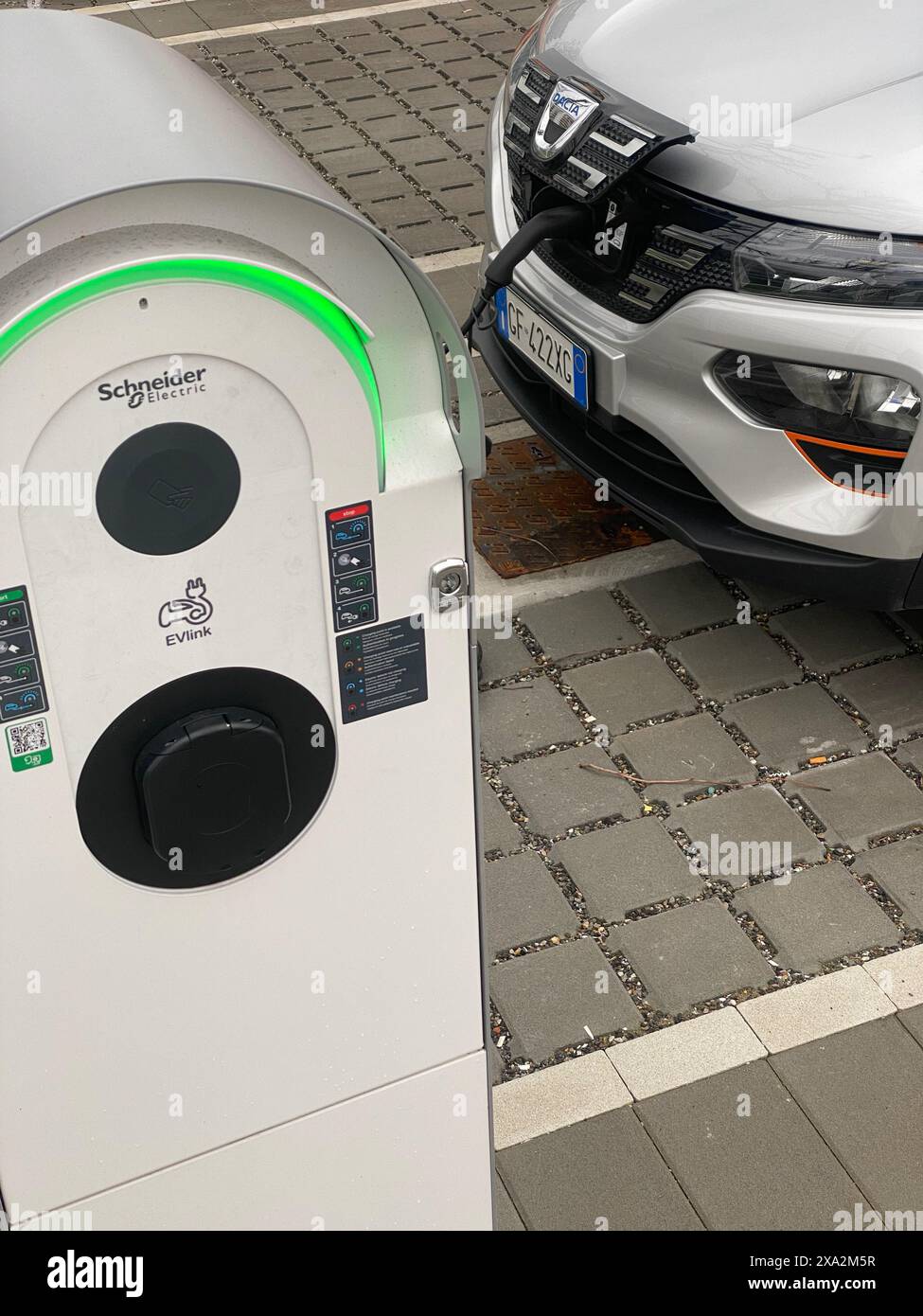 Cremona, Italy - May 2nd 2024 Modern electric vehicle is being charged at a public charging station, showcasing the growing adoption of sustainable tr Stock Photo