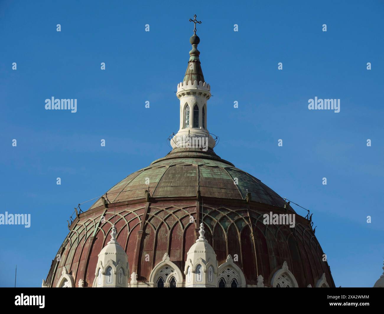 Church dome in detail with clear structure and cross on top in front of blue sky, Madrid, Spain Stock Photo