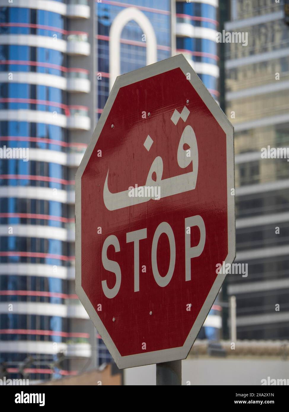 Traffic sign with Arabic and English lettering in front of modern skyscrapers, Abu Dhabi, United Arab Emirates Stock Photo