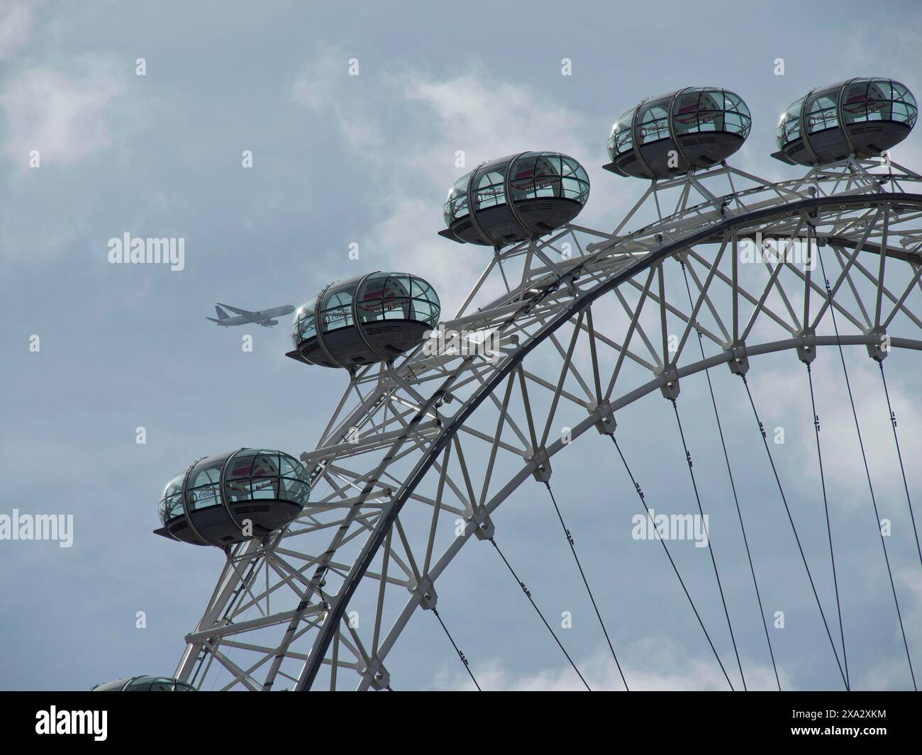 Detail of the Ferris wheel with a view of the capsules and an aeroplane ...
