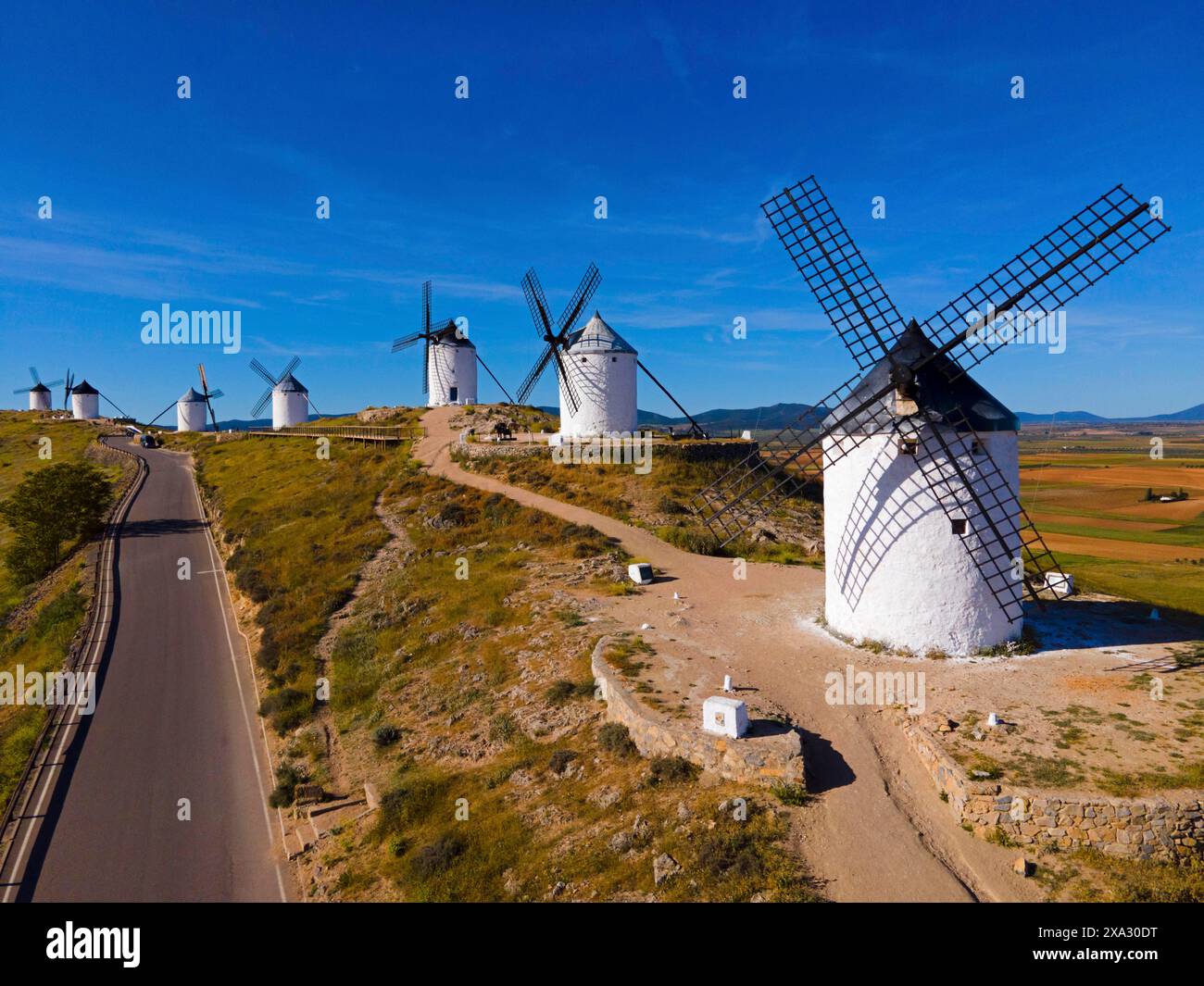 Series Of Windmills Along A Road On A Sunny Hill In A Wide Summer series-of-windmills-along-a-road-on-a-sunny-hill-in-a-wide-summer