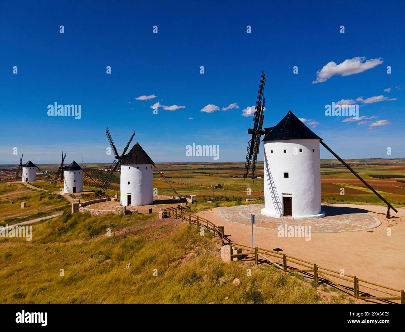 Grouped Windmills On A Hill Under A Bright Blue Sky In A Vast Summer 