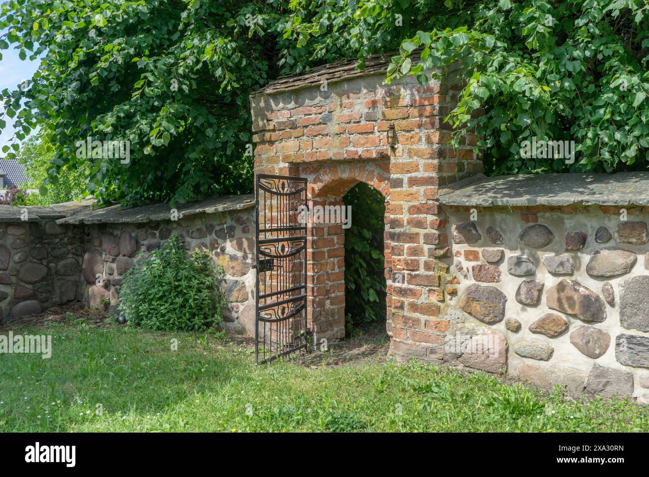 Wall made of field stones and entrance to the cemetery in Ballerstedt, Saxony-Anhalt, Germany Stock Photo