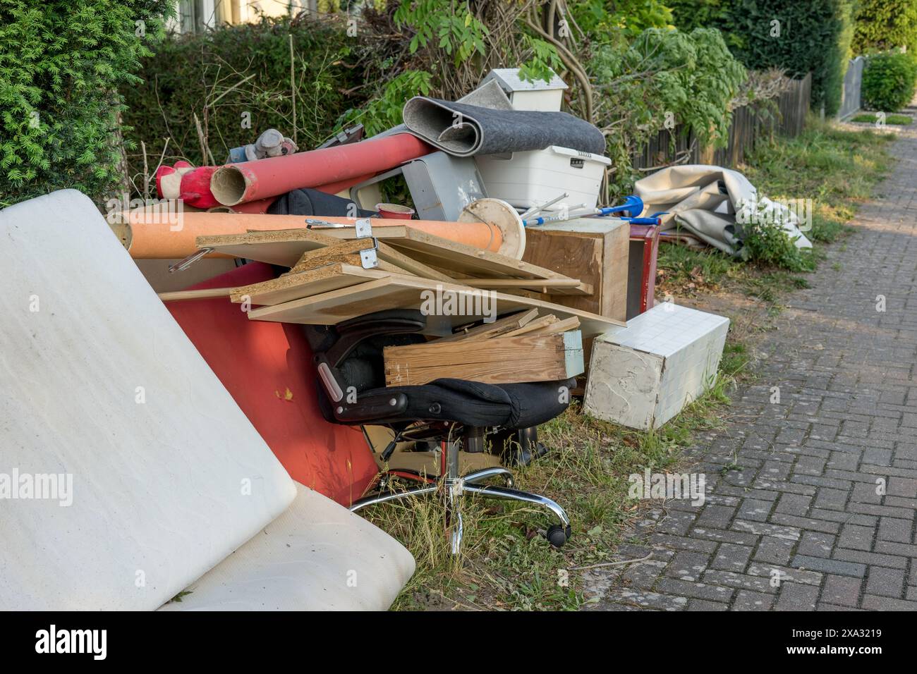 Pile of bulky waste on the side of the road with wooden furniture