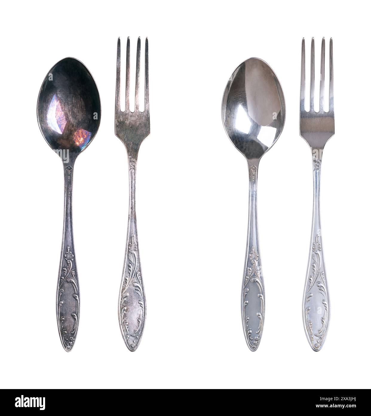 Sterling silver spoon and fork, tarnished and cleaned, isolated from above. On the left side with dark layers of corrosion, on the right cleaned. Stock Photo