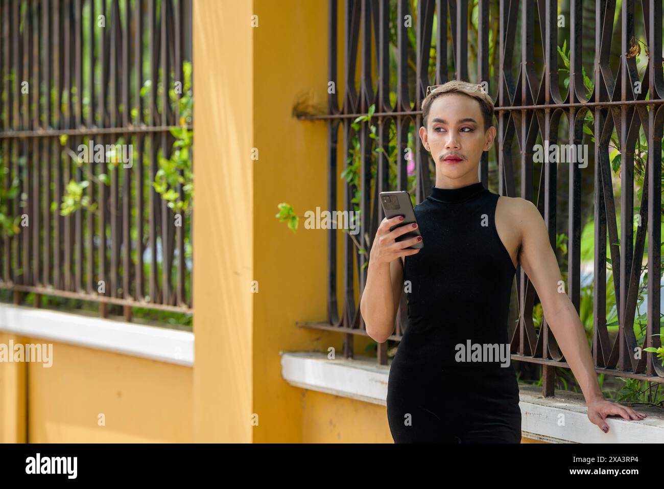 Portrait of beautiful Asian queer LGBT community supporter man with mustache wearing lipstick and jumpsuit Stock Photo