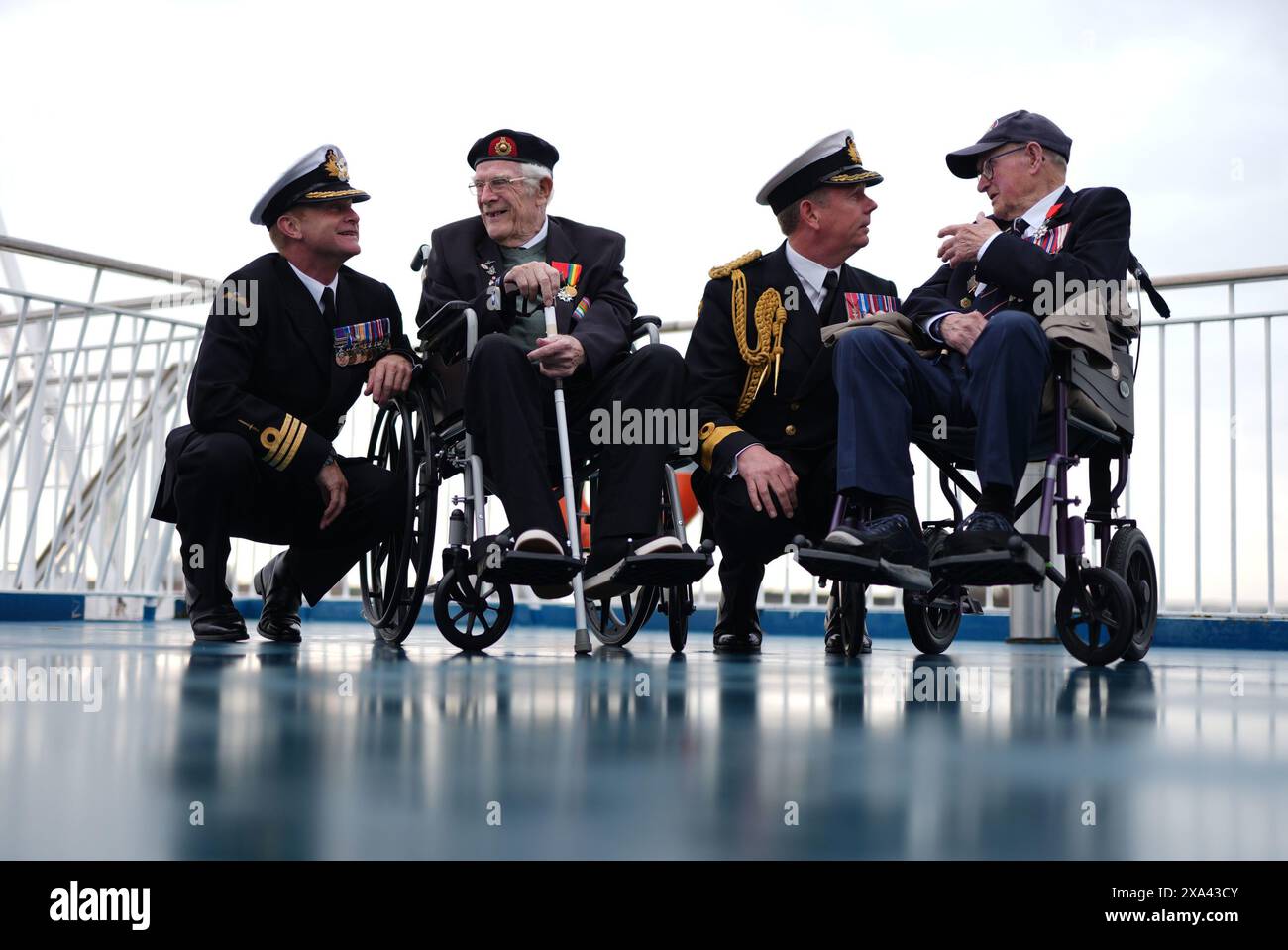 RETRANSMITTING AMENDING SPELLING OF NAMES (left to right) Royal Navy Commander Glen Hinson, D-Day veteran Jim Grant, Royal Navy Commodore John Boyce, and D-Day veteran Charles Horne, on board the Brittany Ferries ship Mont St Michel as it prepares to sail from Portsmouth Harbour in the UK to Ouistreham, in Caen, France, carrying 31 D-Day and Normandy veterans who are travelling with the Royal British Legion and Spirit of Normandy Trust to take part in commemorations to mark the 80th anniversary of D-Day. Picture date: Tuesday June 4, 2024. Stock Photo