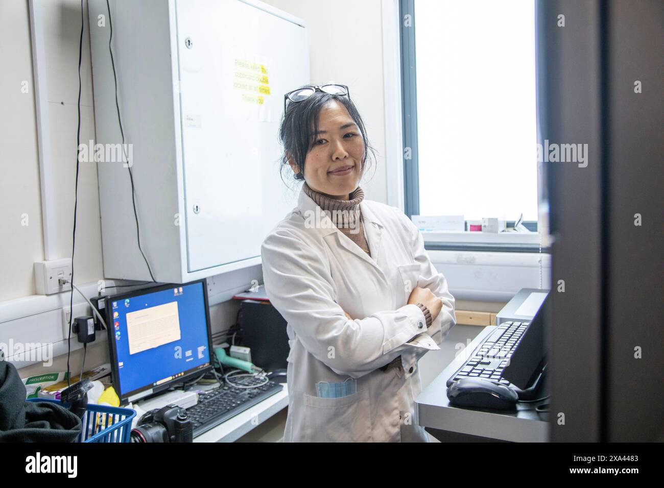 Scientist standing in a lab of a medical practice with computer equipment, UK Stock Photo