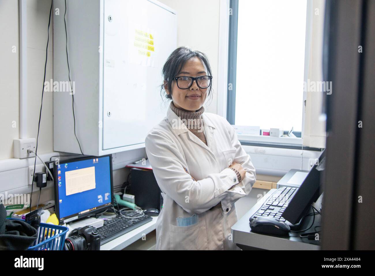 Scientist standing in a lab of a medical practice with computer equipment, UK Stock Photo