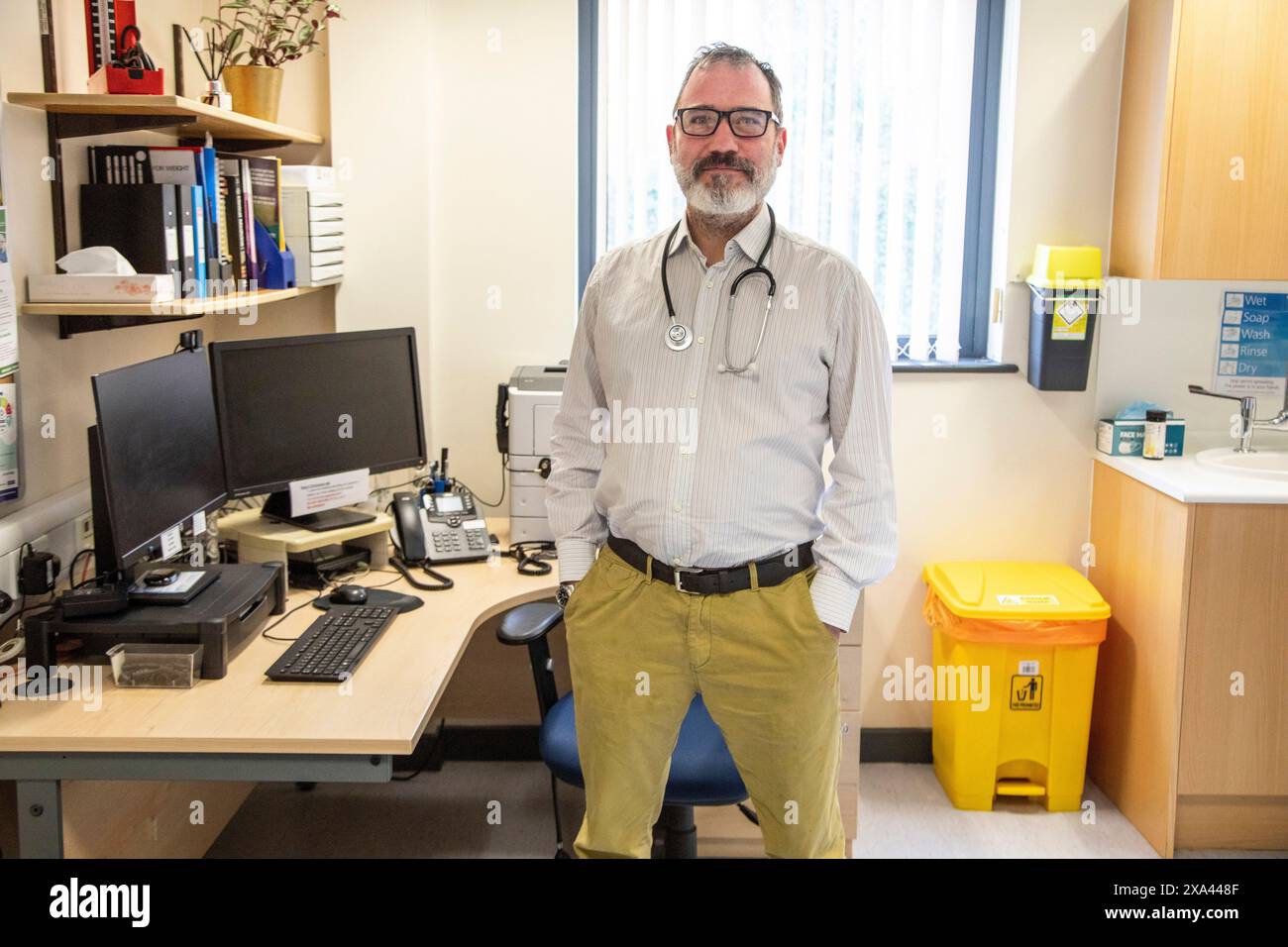 Doctor standing confidently in his office Stock Photo